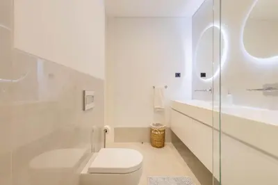 a white bathroom with a toilet and a sink at Villa CLIFF HEAVEN HOUSE in Calheta