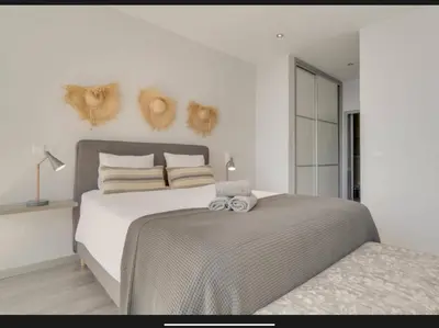a white bedroom with a large bed and a window at Villa Rubydom by Turin in Arco da Calheta