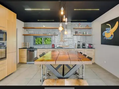 a kitchen with a wooden table in a room at Villa Rubydom by Turin in Arco da Calheta