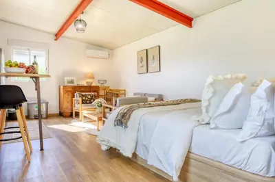 a bedroom with a white bed and a desk at O Miminho, a Home in Madeira in São Jorge