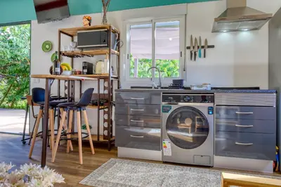 a kitchen with a washing machine and a sink at O Miminho, a Home in Madeira in São Jorge