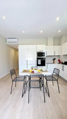 a kitchen and dining room with a table and chairs at In City - Funchal Heart with Rooftop in Funchal