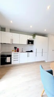 a kitchen with white cabinets and a blue chair at In City - Funchal Heart with Rooftop in Funchal