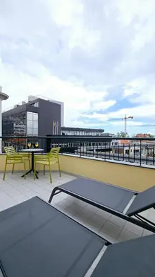 a patio with a table and yellow chairs on a roof at In City - Funchal Heart with Rooftop in Funchal