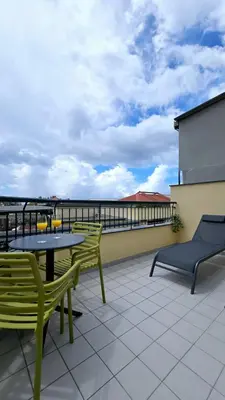 a patio with a table and chairs on a roof at In City - Funchal Heart with Rooftop in Funchal