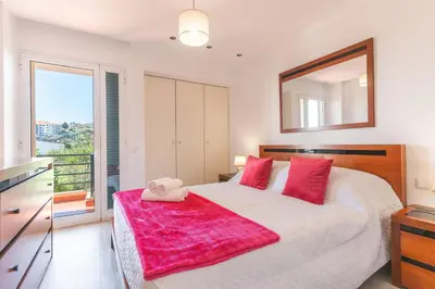 a bedroom with a large bed with a pink blanket on it at Sol Garajau Apartment by Atlantic Holiday in Santa Cruz