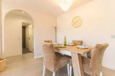 a dining room with a table and a clock on the wall at Sol Garajau Apartment by Atlantic Holiday in Santa Cruz
