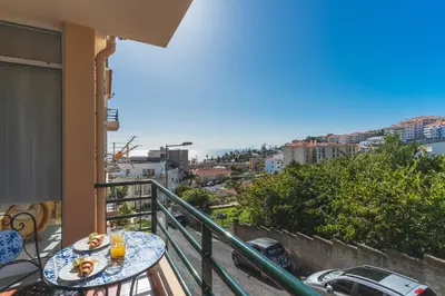 a balcony with a table and a view of the ocean at Sol Garajau Apartment by Atlantic Holiday in Santa Cruz