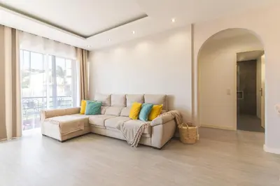 a living room with a couch with colorful pillows at Sol Garajau Apartment by Atlantic Holiday in Santa Cruz