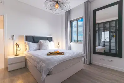 a white bedroom with a bed with a tray of fruit on it at Midnight House by Atlantic Holiday in Câmara de Lobos