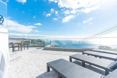 a balcony with benches and a view of the ocean at Midnight House by Atlantic Holiday in Câmara de Lobos