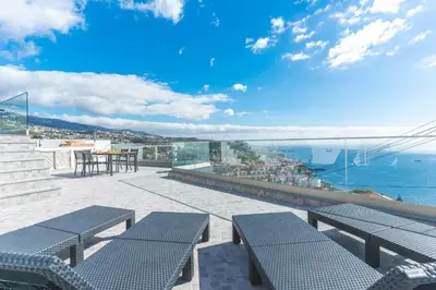a balcony with benches and a view of the ocean at Midnight House by Atlantic Holiday in Câmara de Lobos