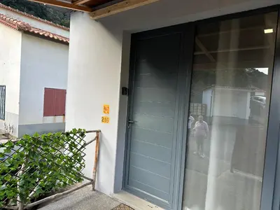 a blue door of a house with two people standing outside at Cantinho S & F in Machico