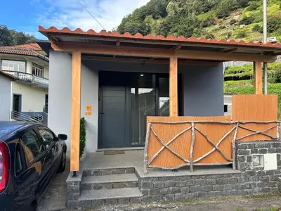 a house with a porch and a car parked outside at Cantinho S & F in Machico