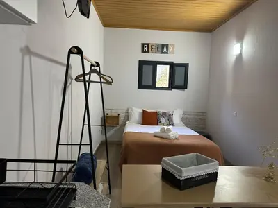 a small bedroom with a bed and a desk at Cantinho S & F in Machico