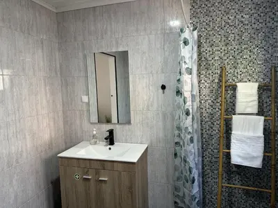 a bathroom with a sink and a shower with a mirror at Cantinho S & F in Machico