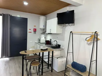 a kitchen with a table and chairs in a room at Cantinho S & F in Machico
