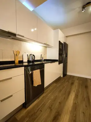 a kitchen with white cabinets and a black stove top oven at Vitoria's Vale in Funchal