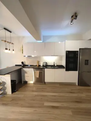 a kitchen with white cabinets and black appliances at Vitoria's Vale in Funchal
