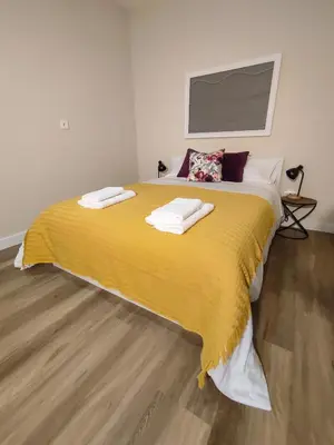 a bedroom with a large yellow bed with towels on it at Vitoria's Vale in Funchal