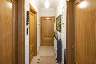 a hallway with a wooden door and a hallway sidx sidx sidx at Fairview Golfside Apartment at Boavista in Atalaia