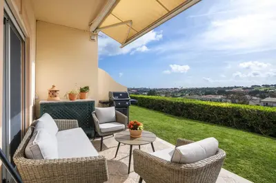 a patio with chairs and a table and a grill at Fairview Golfside Apartment at Boavista in Atalaia