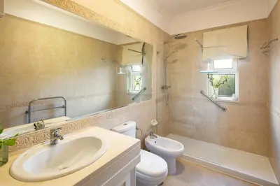 a bathroom with a sink and a toilet and a mirror at Fairview Golfside Apartment at Boavista in Atalaia