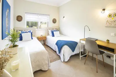 two beds in a room with a desk and a desk at Fairview Golfside Apartment at Boavista in Atalaia