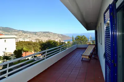 a table with two fruits and a vase with a plant at Ocean View II in Funchal