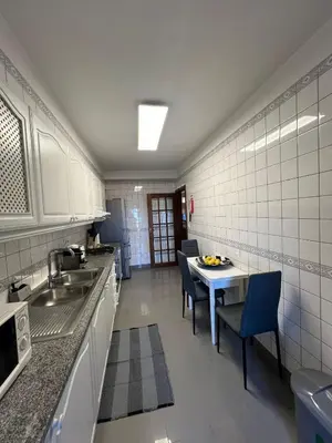 a kitchen with a sink and a table with chairs at Ocean View II in Funchal