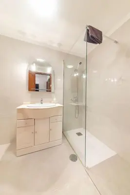 a white bathroom with a sink and a shower at Esmael Apartment By Mth in Funchal