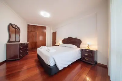 a bedroom with a large bed and wooden floors at Esmael Apartment By Mth in Funchal
