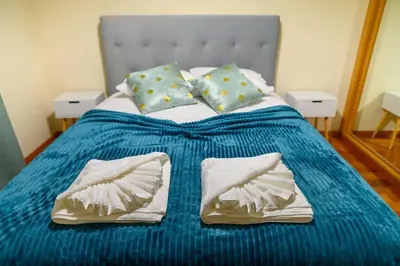 a bed with a blue blanket and pillows on it at Gorete Apartment 3 by Mth in Funchal