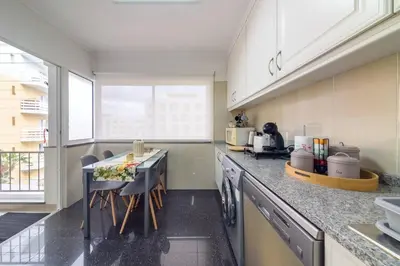 a kitchen with a counter with a table and chairs at Gorete Apartment 3 by Mth in Funchal