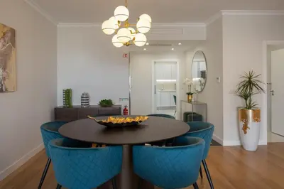 a dining room with a table and blue chairs at Casa Branca Penthouse by An Island Apart in Funchal