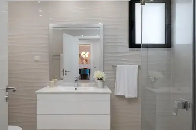 a bathroom with a white sink and a mirror at Casa Branca Penthouse by An Island Apart in Funchal