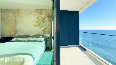 a bedroom with a bed and a view of the ocean at Sea Front in Câmara de Lobos