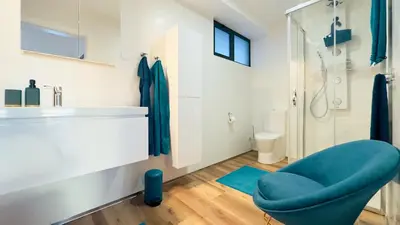 a bathroom with a blue chair and a shower at Sea Front in Câmara de Lobos