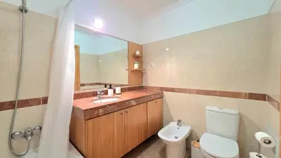a bathroom with a toilet and a sink and a mirror at Atlantic Breeze in Câmara de Lobos