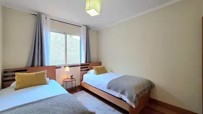 a bedroom with two beds and a window at Atlantic Breeze in Câmara de Lobos