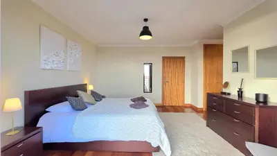 a bedroom with a large bed and a dresser at Atlantic Breeze in Câmara de Lobos