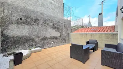 a balcony with two chairs and a wall at Atlantic Breeze in Câmara de Lobos