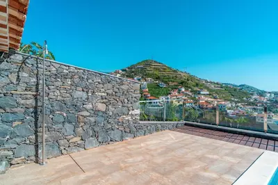 a garden with trees in the middle of a yard at Camara De Lobos Lux Villa in Câmara de Lobos