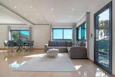 a house with a swimming pool next to the ocean at Camara De Lobos Lux Villa in Câmara de Lobos