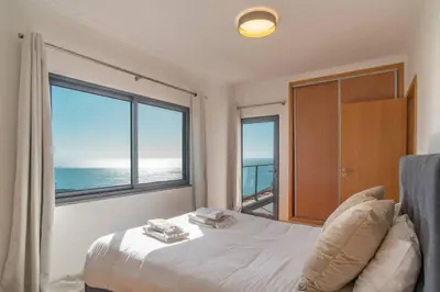 a bedroom with two beds and a large window at Camara De Lobos Lux Villa in Câmara de Lobos