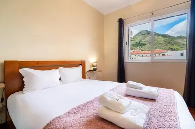 a bedroom with a bed with two towels on it at GuestReady - Machico Apartment with Balcony in Machico