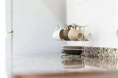 a group of cups hanging on a kitchen counter at GuestReady - Machico Apartment with Balcony in Machico