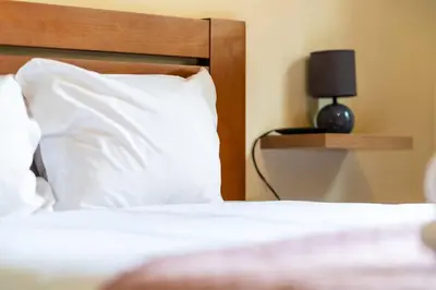 a bedroom with a bed with white pillows and a lamp at GuestReady - Machico Apartment with Balcony in Machico