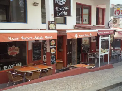 a restaurant with plants in front of a building at St James Apartment in Luz