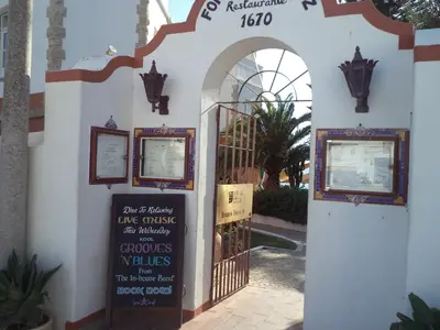 a restaurant with tables and chairs outside of it at St James Apartment in Luz